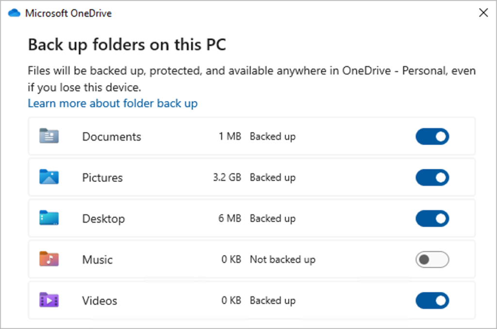 Diálogo Manage backup do OneDrive em inglês, com as pastas Documents, Pictures e Desktop activadas para backup e Music e Videos visíveis na lista