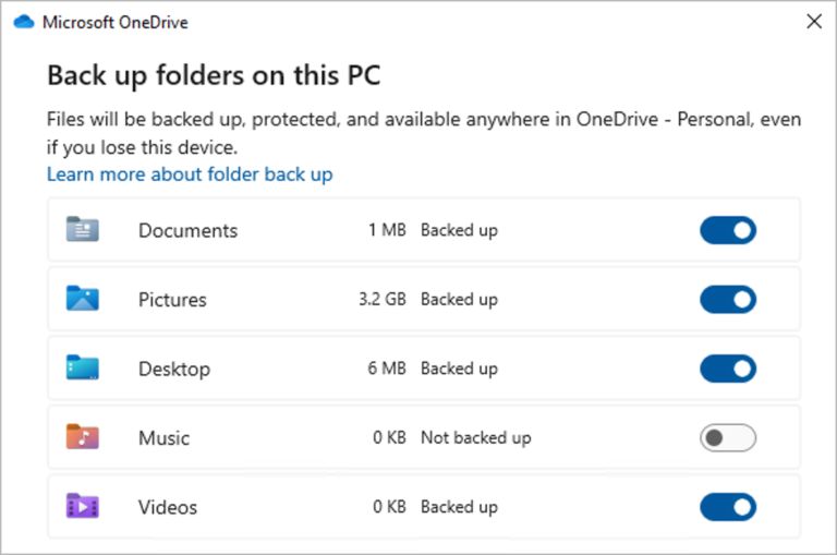 Diálogo Manage backup do OneDrive em inglês, com as pastas Documents, Pictures e Desktop activadas para backup e Music e Videos visíveis na lista
